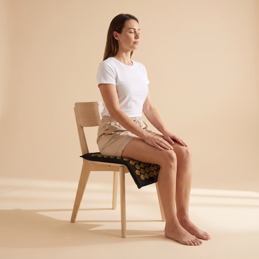 Position assise : le tapis d'acupression PuraDorse plié sur l'assise d'une chaise