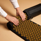 Le tapis d'acupression PuraDorse roulé et glissé dans son sac de transport